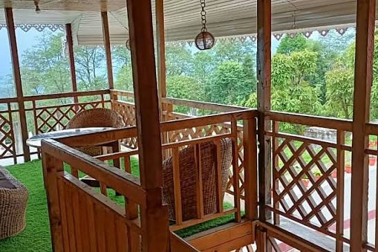 Master Room Kanchenjunga — private wooden balcony with valley views