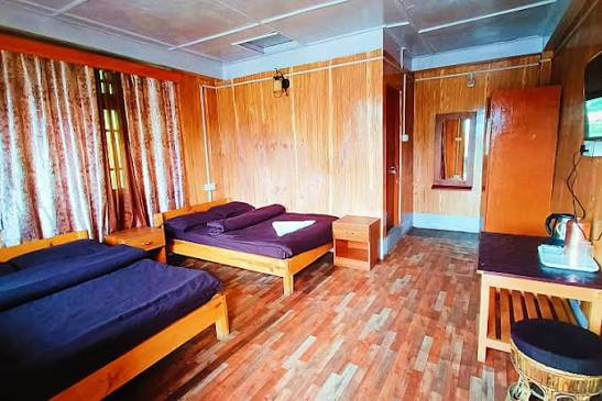 Wooden Room Pine — warm wood-panelled bedroom with double and single beds