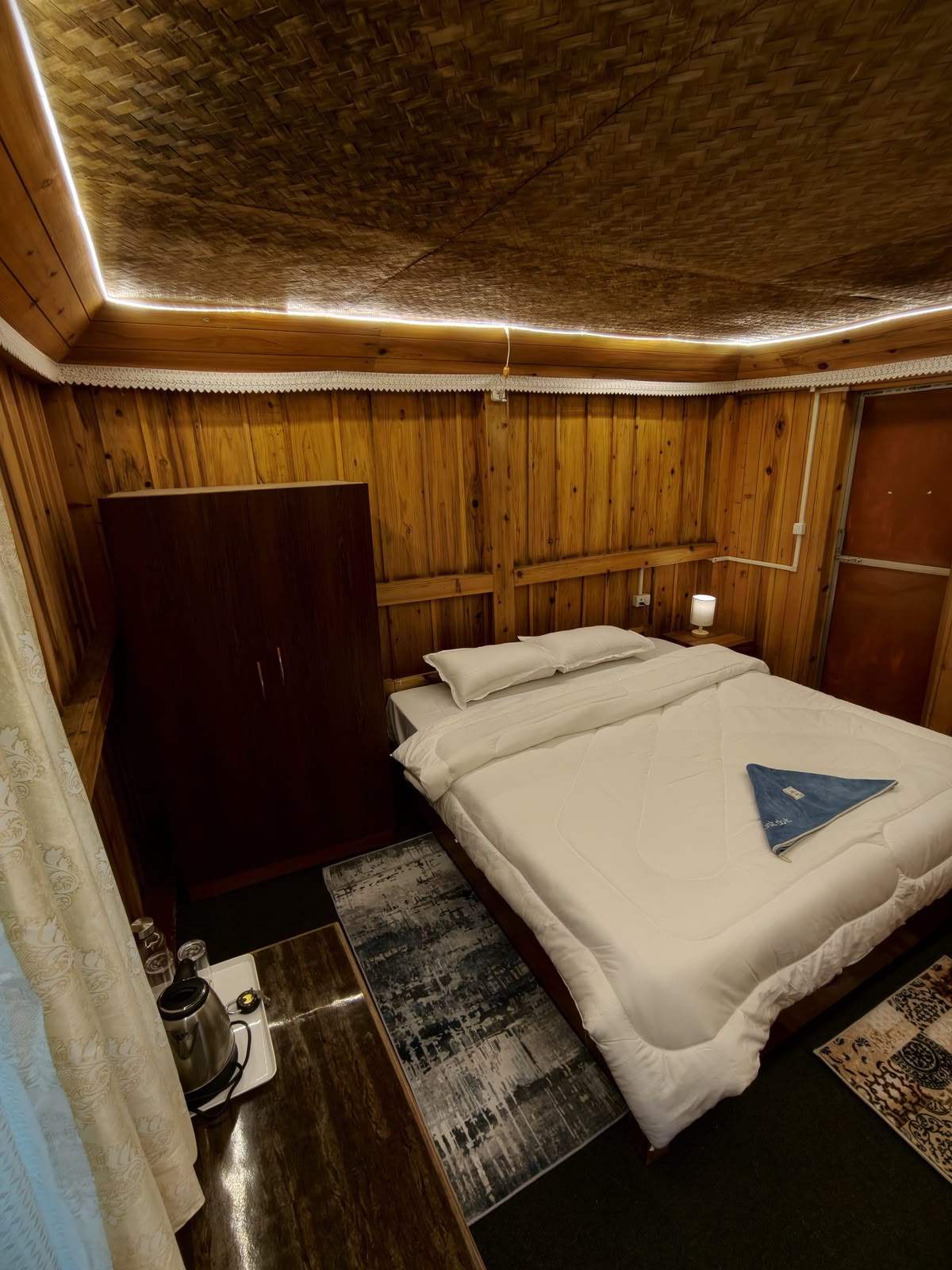 Cedar Nest — double bed and wardrobe under a woven bamboo ceiling
