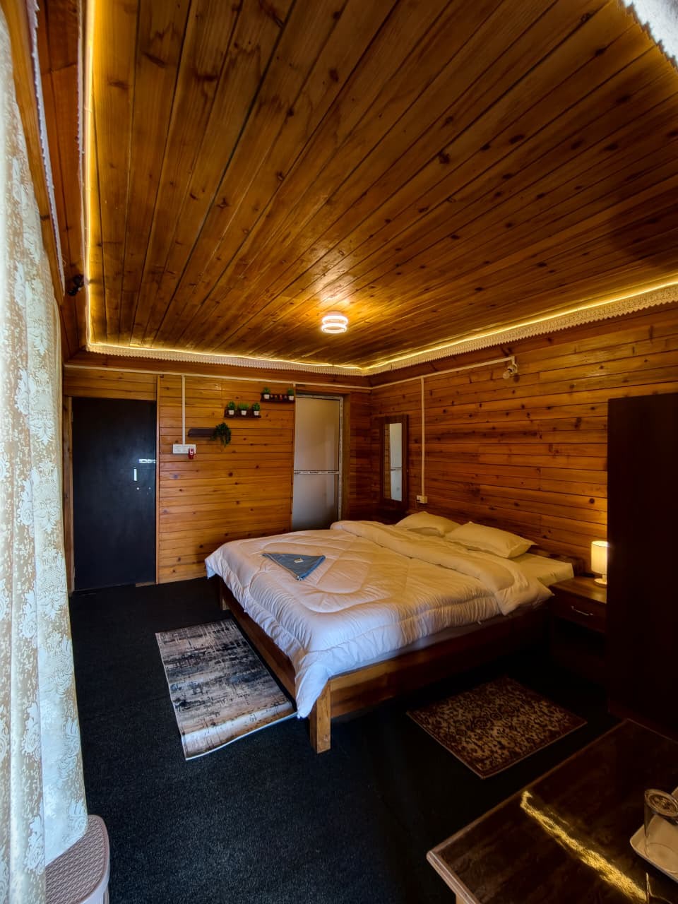 Pine Nest — cozy wood-panelled room with neatly made bed